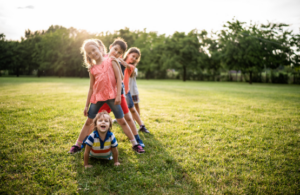 Kinderen staan speels op grasveld tijdens buiten bewegen en spelen