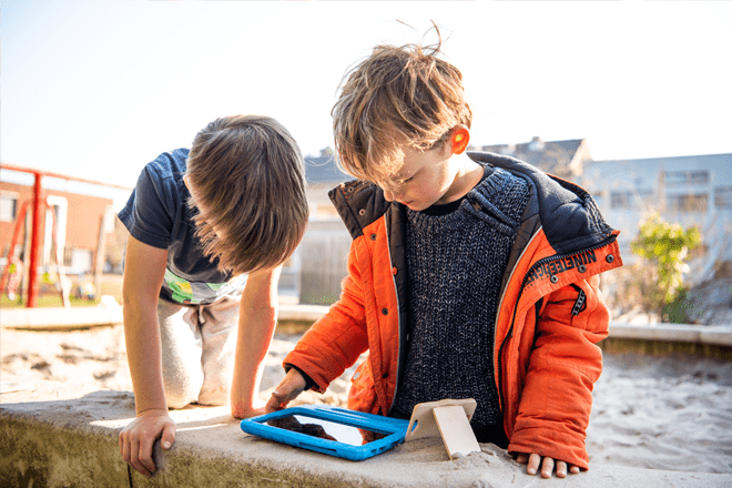 Jongetjes spelen Springloop bij zandbak schoolplein